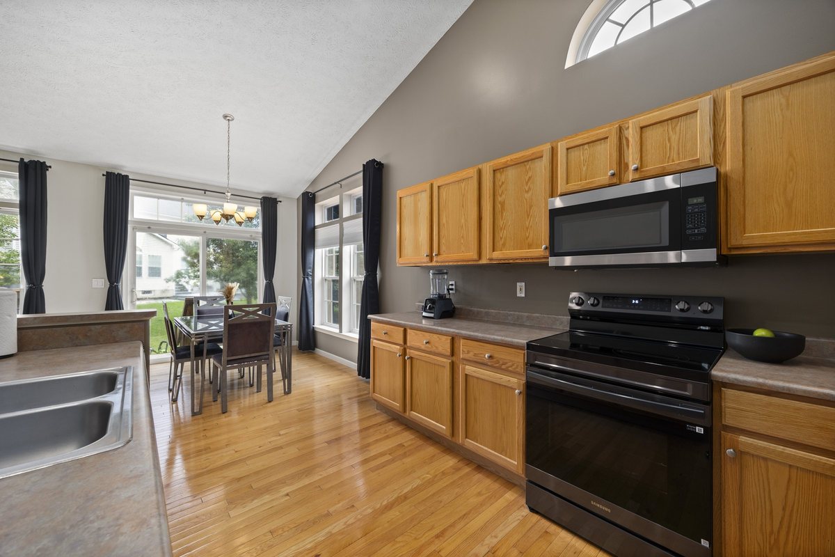 Kitchen range wall with oak cabinets, opening to the dining area