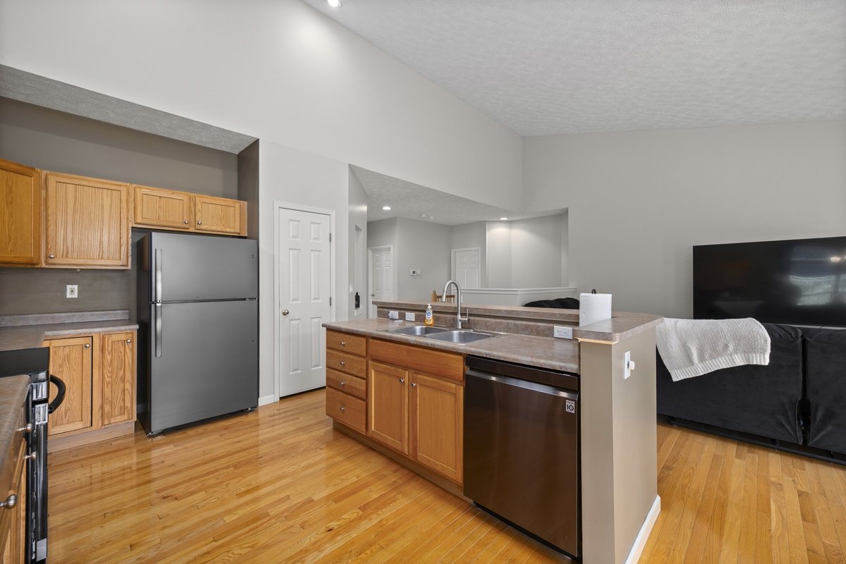 Kitchen sink, dishwasher, refrigerator, and pantry door