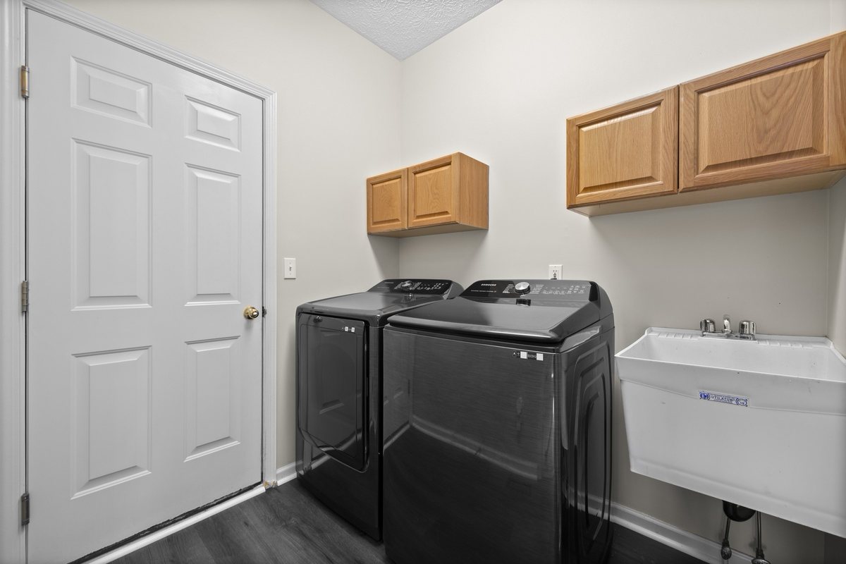 Main-floor laundry room with washer, dryer, and utility sink
