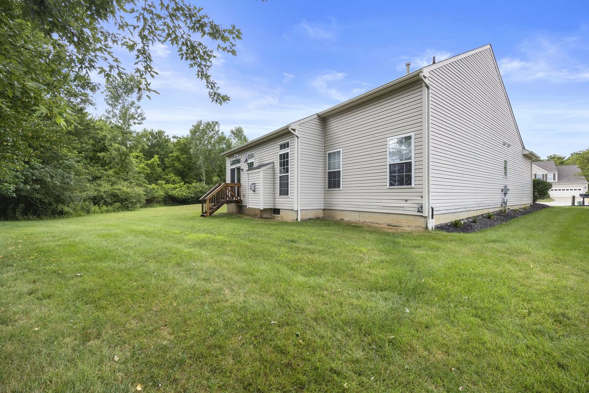 Rear exterior and lawn with the tree line behind